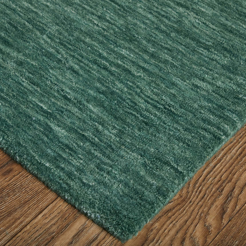 Close-up of the Feizy Luna Modern Solid Green and White area rug showing texture and color variations. Corner