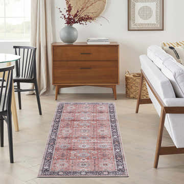 Living room scene with Nourison Fulton Rust Vintage rug, wood dresser, white sofa, and modern decor.