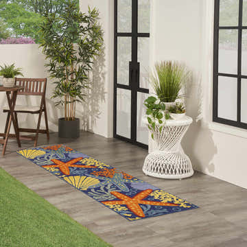 Outdoor patio scene with a Nourison Aloha Navy Multicolor runner rug featuring starfish and seashell motifs.