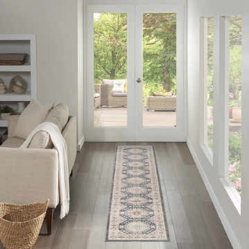 Hallway scene with a Nourison Serenity Home Ivory Blue Vintage runner rug, light wood floors, and outdoor patio view.