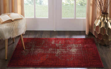 Entryway with Nourison Karma Red Vintage rug, wood floors, white door, and gold accents.
