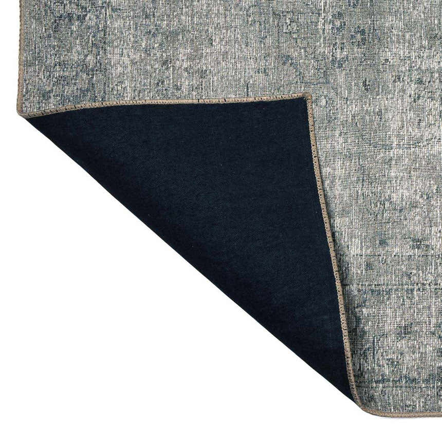 Close-up of the Four Hands Morelli Blue Area Rug showing the rug's backing and woven texture. Fold