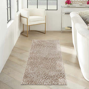 Modern living room with Nourison Desire Camel Silver rug, white sofa, and gold accent chair.