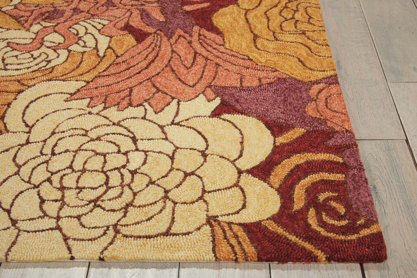 Close-up of the Nourison South Beach Spice Area Rug. Floral design in spice tones: cream, gold, orange, and burgundy. Handmade rug texture.