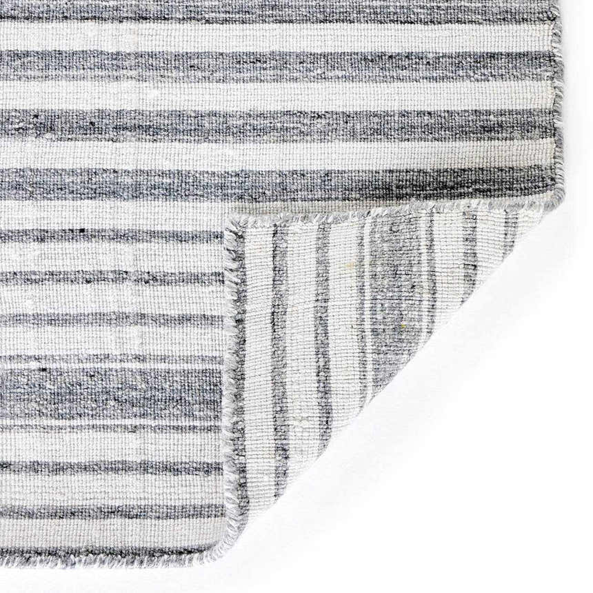 Close-up of the Four Hands Selena Outdoor Rug - Blue Stripe, showing the hand woven texture and striped pattern. Fold