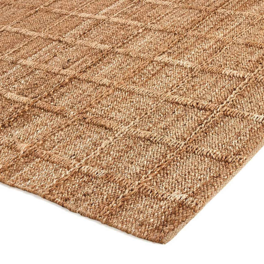 Close-up of the Four Hands Grid Jute Rug. Natural woven jute rug with a raised grid pattern. Farmhouse style. Corner