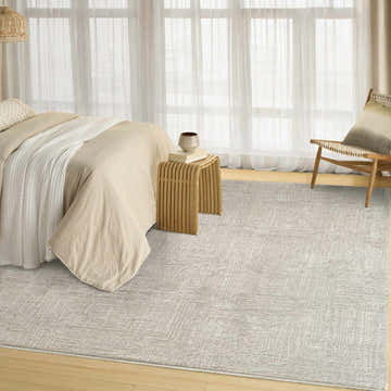 Light, airy bedroom scene with DKNY DK014 Madison Grey rug, beige bedding, wood accents, and sheer curtains.