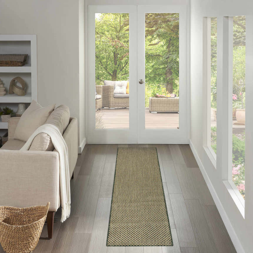 Hallway scene with a Nourison Courtyard Green Modern Area Rug runner, light wood floors, and view to outdoor patio.