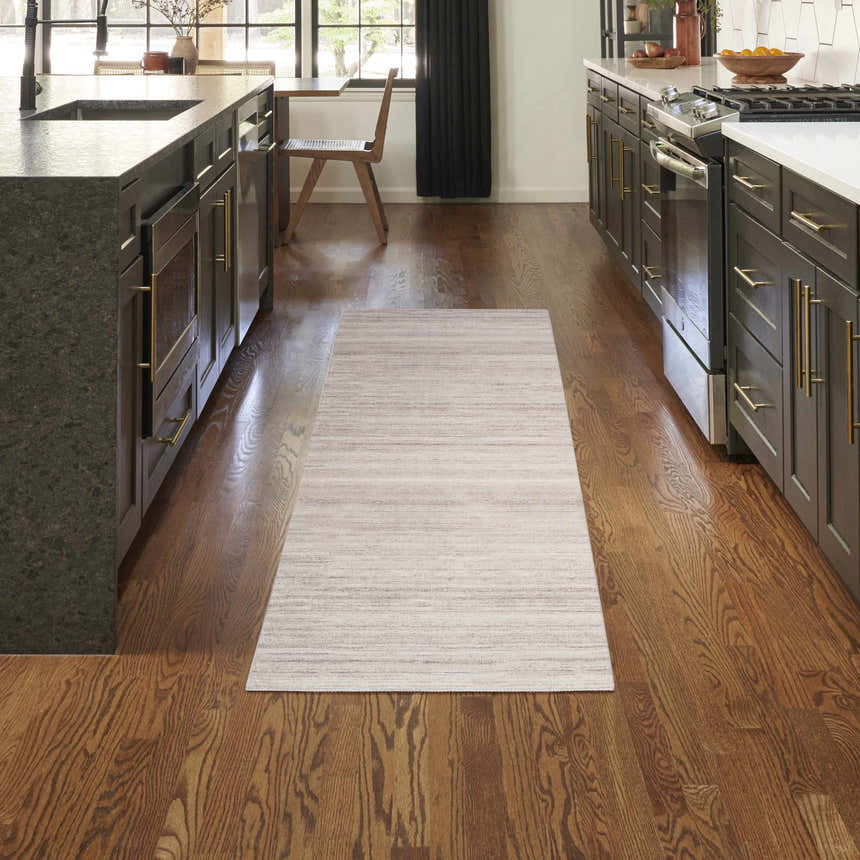 Modern kitchen with Nourison Essentials Ivory Mocha rug runner between dark cabinets and wood floors.