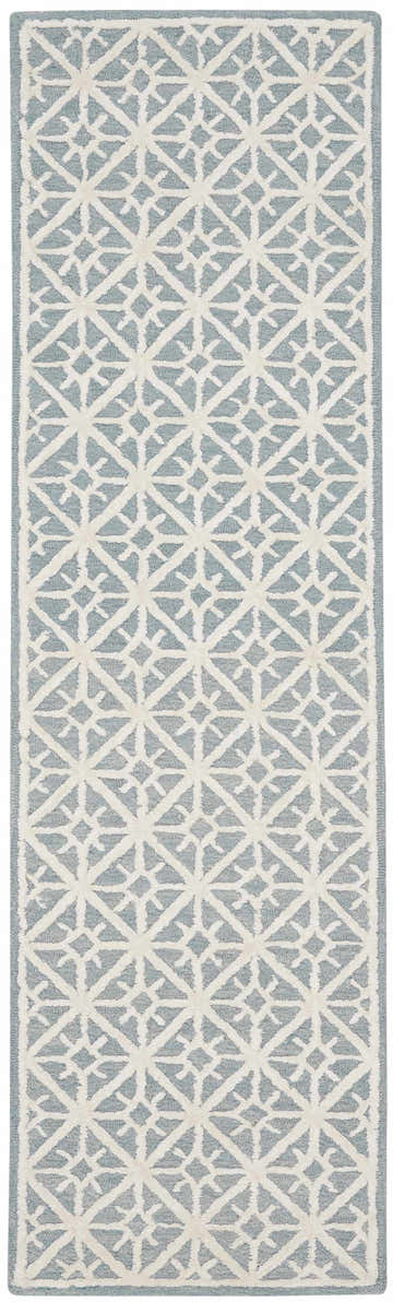Close-up of the Nicole Curtis Series 2 Light Blue rug, showing a geometric lattice pattern in light blue and ivory.