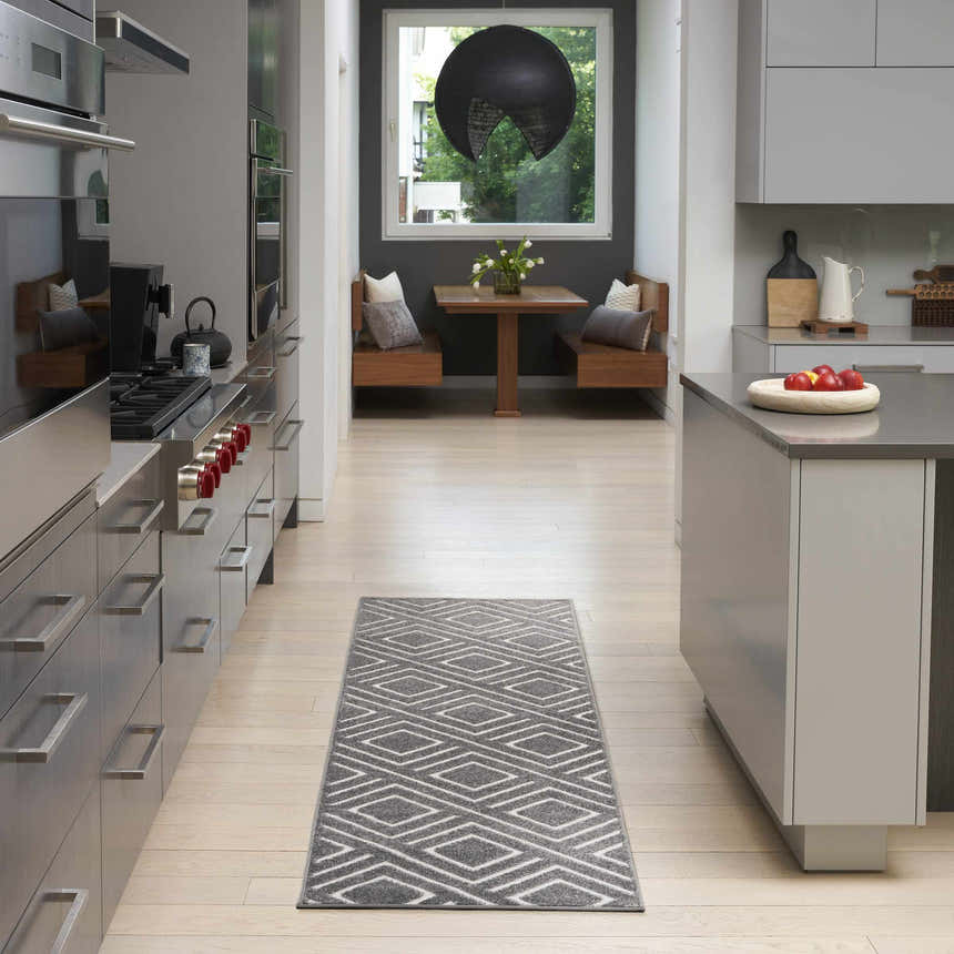 Modern kitchen with stainless steel appliances and Nourison Care Free Grey runner rug.
