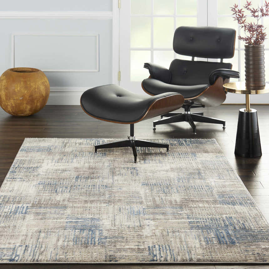 Modern living room with black leather chair and Nourison Solace Ivory Grey Blue Area Rug.