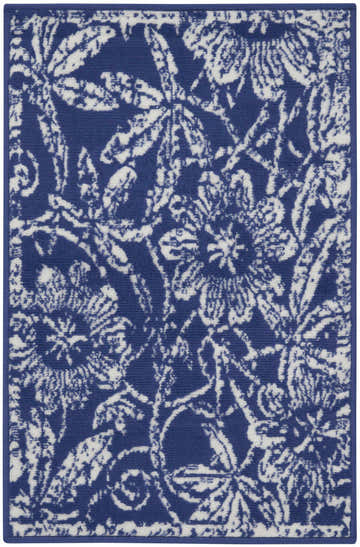 Close-up of the Nourison Whimsicle Navy Farmhouse Indoor Area Rug. Features a white floral and leaf pattern on a navy blue background.
