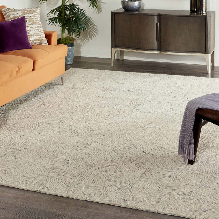 Living room with orange sofa and Nourison Interlock Ivory Multicolor rug on dark wood floor.