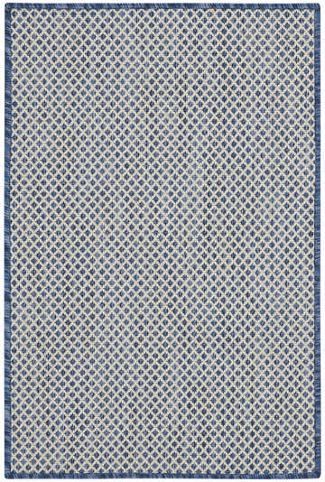 Close-up of Nourison Courtyard Ivory Blue rug. Diamond pattern in shades of blue and ivory. Machine-made polypropylene texture.