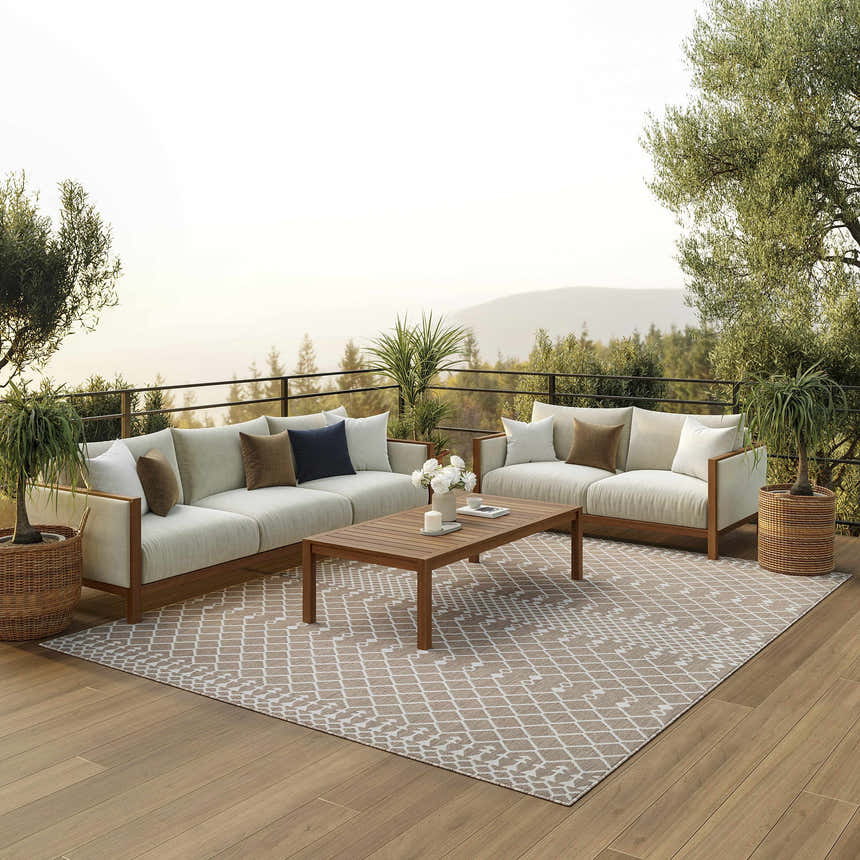 Outdoor patio scene with sofas and Nourison Positano Beige Modern Area Rug. The rug has a geometric pattern.