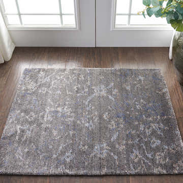 Nourison Lucent Coal vintage rug in entryway. Dark brown wood floors and natural light. Bamboo silk-like fiber texture.