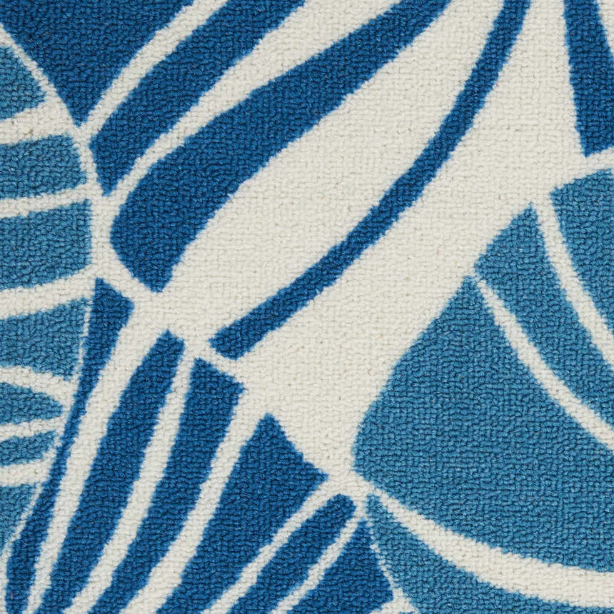 Close-up of the Waverly Sun N' Shade Blue Tropical Area Rug, featuring a light blue tropical leaf pattern on a white background.