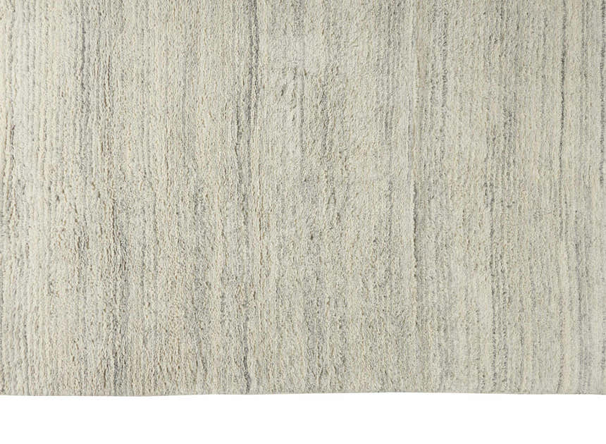 Close-up of the silver gray Calvin Klein Agadir shag rug. Handmade wool rug with a soft, textured pile.