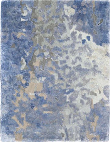 Close-up of the Nourison Prismatic Denim Rug. Abstract pattern in shades of denim blue, gray, and ivory. Handmade texture.