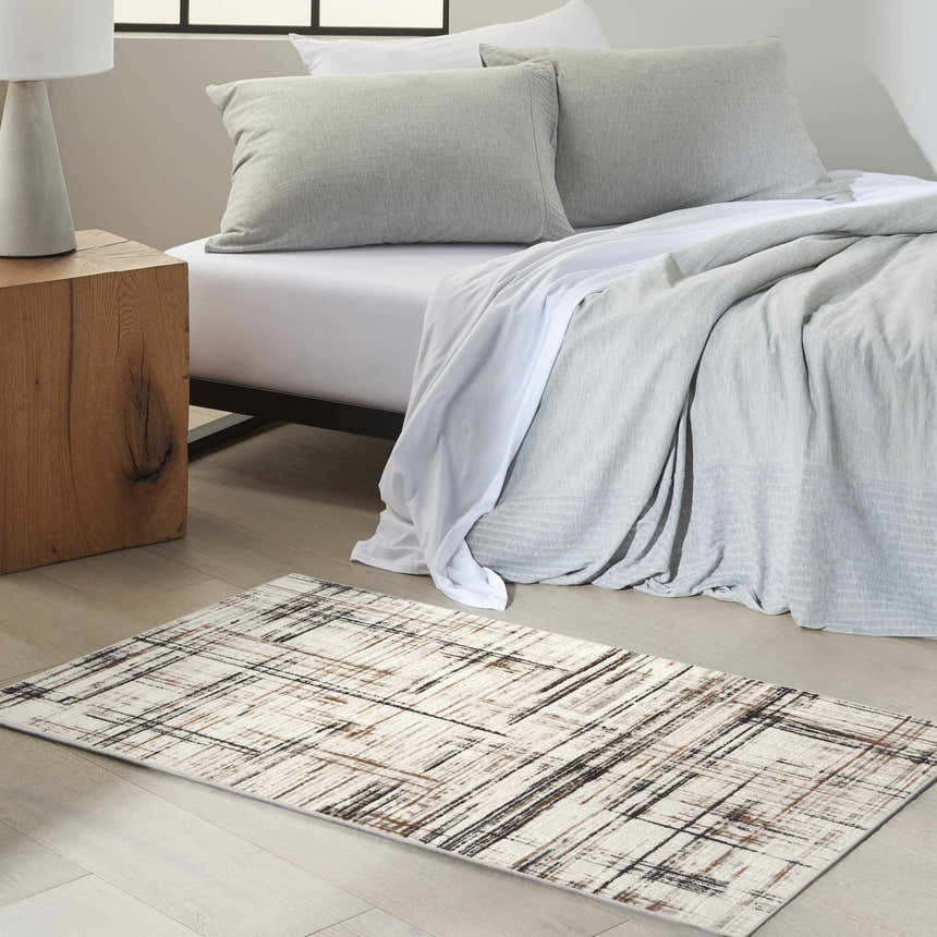 Bedroom scene with Calvin Klein CK029 Captivating Ivory Multicolor rug, wood nightstand, and gray bedding.