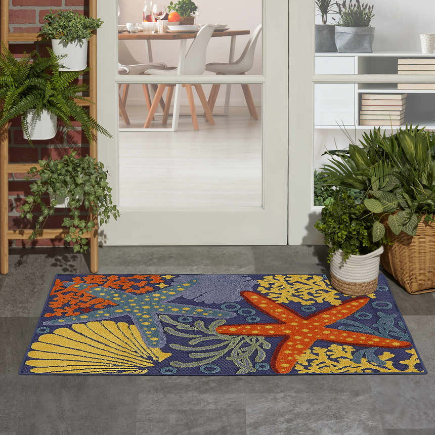Entryway scene with Nourison Aloha Navy Multicolor rug featuring starfish and coral design.