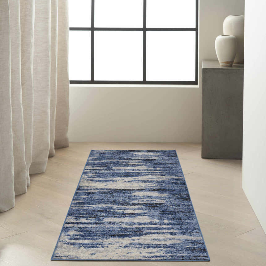 Modern entryway with a Calvin Klein River Flow Blue Grey rug, light wood floors, and neutral decor.