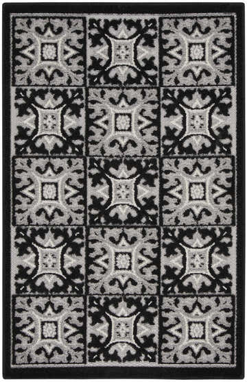 Close-up of the Nourison Aloha Black White Contemporary Area Rug, showcasing its geometric tile pattern and textured weave.