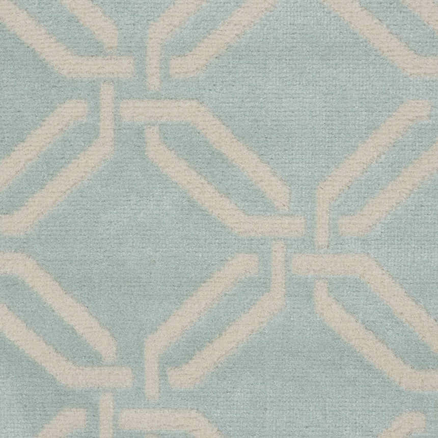 Close-up of the Nourison Jubilant Green rug featuring a geometric, interlocking pattern in light beige and soft green.