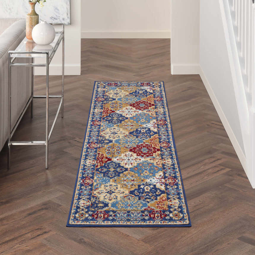 Hallway with Nourison Grafix Multicolor Bohemian runner rug on wood floor. Console table and gray sofa.