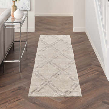 Hallway with Nourison Venosa Ivory/Grey rug runner on dark wood floor. Modern console table with vases. Neutral tones.