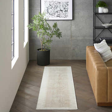 Modern living room with a chestnut leather sofa and DKNY Grand Street Ivory Beige area rug.