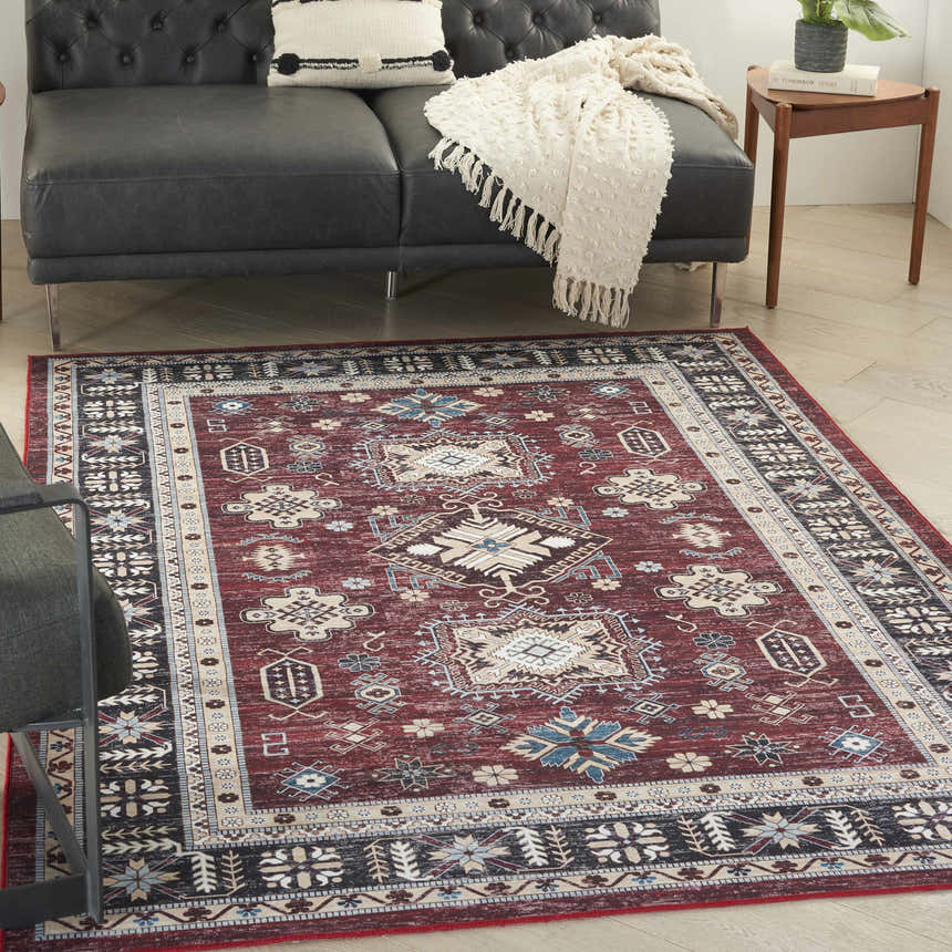 Living room scene with a Nourison Fulton Red Vintage rug, black sofa, and wood side table.