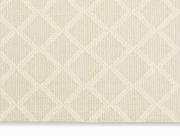 Close up of the cream Calvin Klein Tallahassee rug showing its woven texture and diamond pattern.