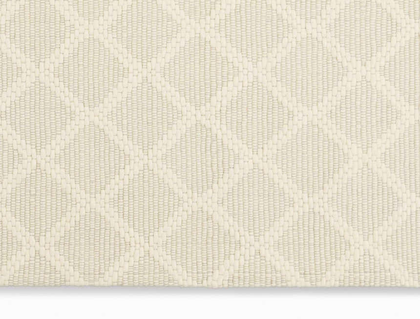 Close up of the cream Calvin Klein Tallahassee rug showing its woven texture and diamond pattern.