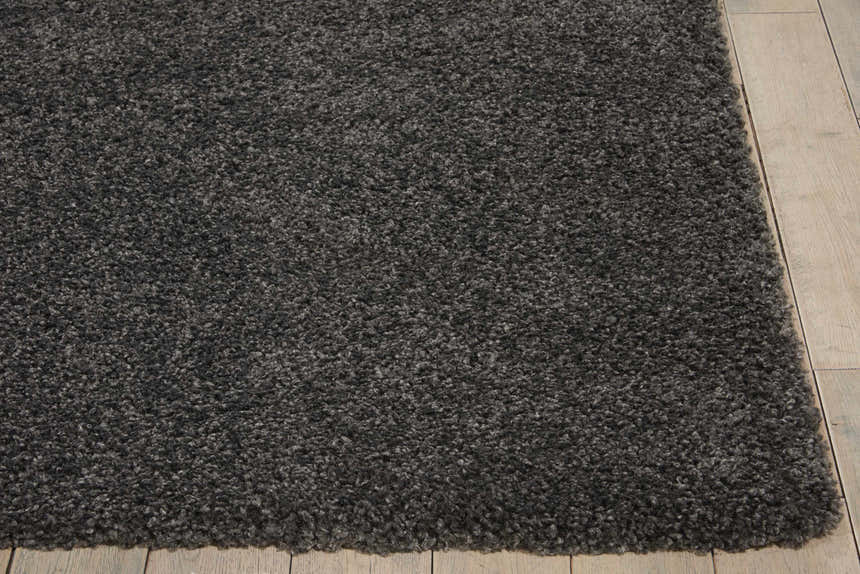Close-up of the plush texture of the Nourison Malibu Dark Grey Shag Rug on a light wood floor.