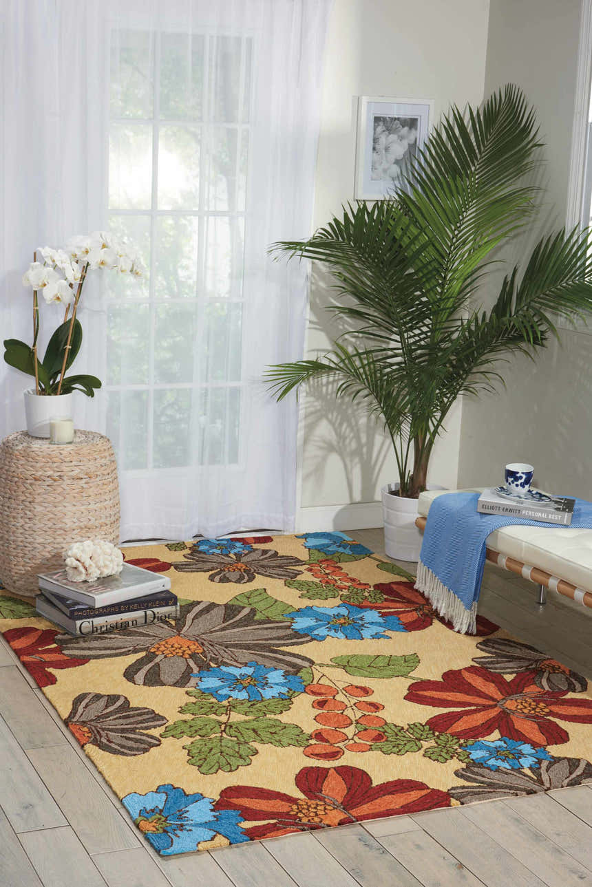 Bright room scene with Nourison South Beach Sand Area Rug. Floral pattern in sandstone, blue, rust, and gray. Coastal decor.