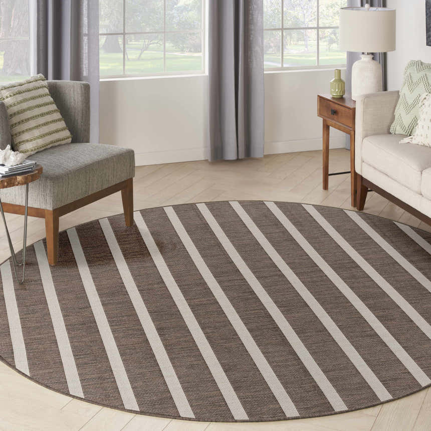 Living room scene with round Nourison Positano Natural Ivory rug. Chestnut stripes, mid-century modern style.