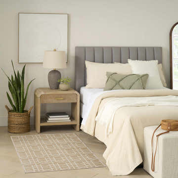 Serene bedroom scene with Nourison Charm Beige Ivory rug, wood nightstand, and neutral bedding.