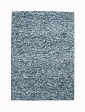 Close-up of the Calvin Klein Tulsa Aqua rug. Plush texture in blended shades of blue. Handmade polyester rug.