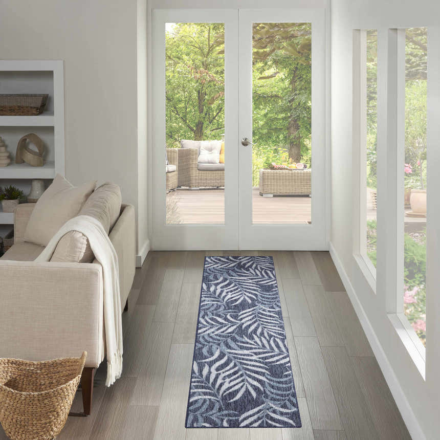 Hallway with a Nourison Garden Oasis Navy Tropical Area Rug runner, leading to an outdoor patio.