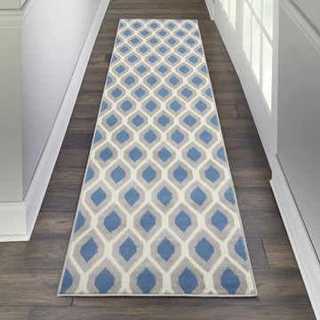 Hallway with Nourison Grafix Blue runner rug. Contemporary geometric pattern in blue, gray, and white on dark wood floors.
