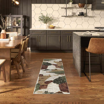 Modern kitchen-dining area with Nourison Nordic Beige Multi runner rug, wood floors, dark cabinets, and island.