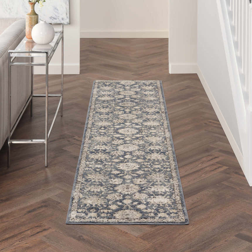 Hallway scene with Nourison Quarry Blue Beige Vintage rug, wood floors, console table, and neutral decor.