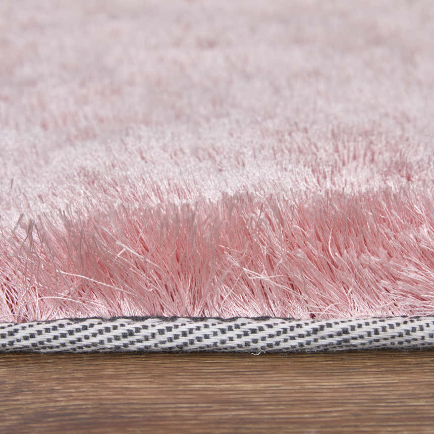 Close-up of the textured Feizy Indochine blush pink area rug, showing the soft pile and woven backing. Pile