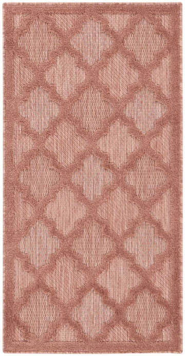Close-up of the Nourison Easy Care Coral Orange rug, featuring a quatrefoil trellis pattern and textured weave.