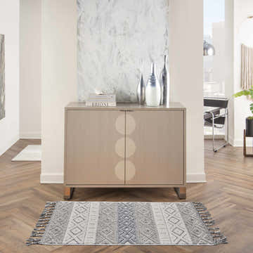 Living room scene with Nourison Paxton Ivory/Slate rug, wood floors, modern cabinet, and city view. Scandinavian style.