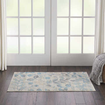 Farmhouse style room featuring Nourison Tranquil Ivory Turquoise rug with blue leaf pattern on dark wood floor.