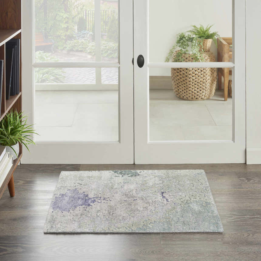 Entryway with Nourison Silk Shadows Blue Green rug, wood floors, and white french doors to a garden.