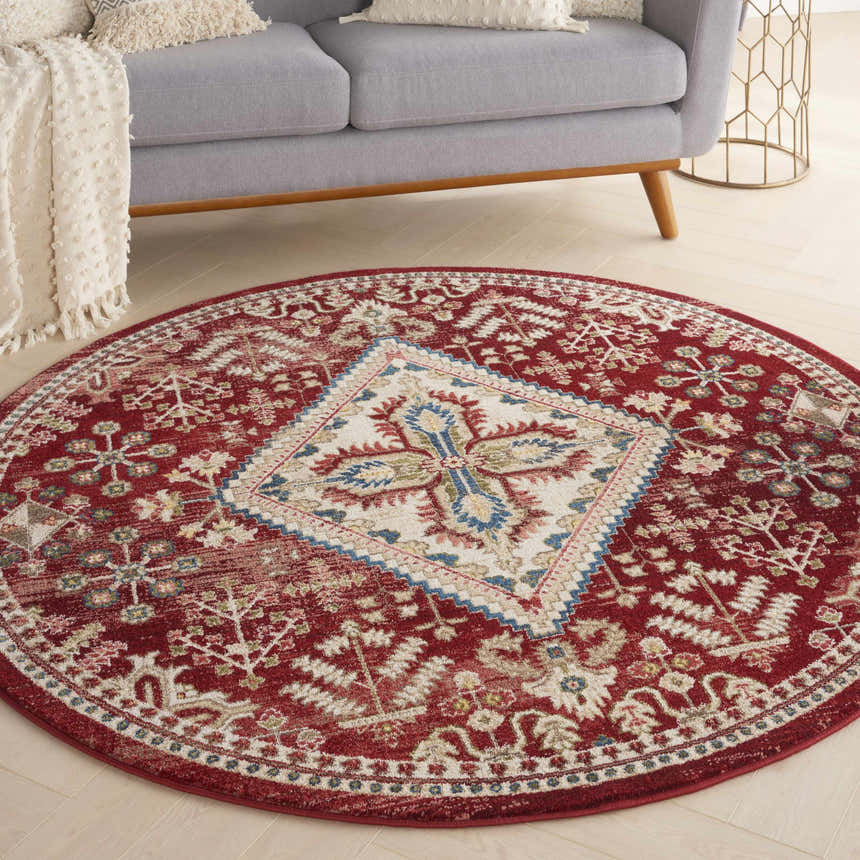 Living room scene with a round Nourison Karisma Brick Ivory rug, gray sofa, and light wood floors. Farmhouse style.